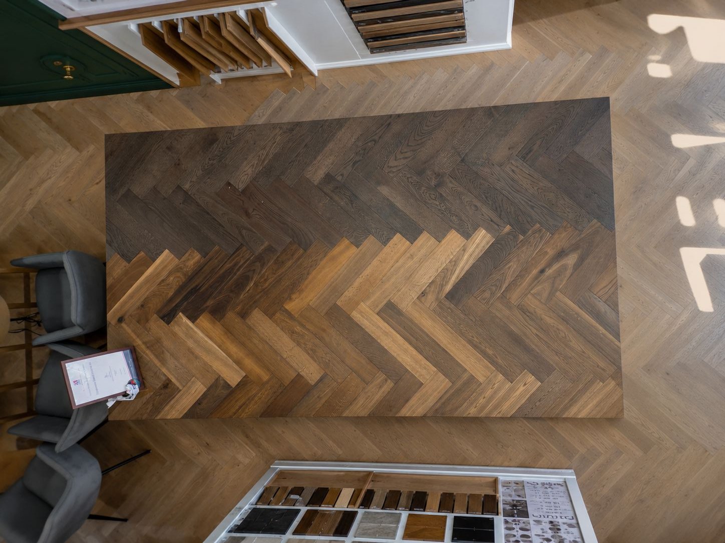 Inside the Timberzone Studio showroom — a herringbone display board showing two oak tones, surrounded by samples and natural light